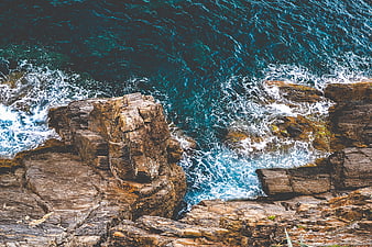 Aerial View of Turquoise Waves Crashing on Rocky Coastline