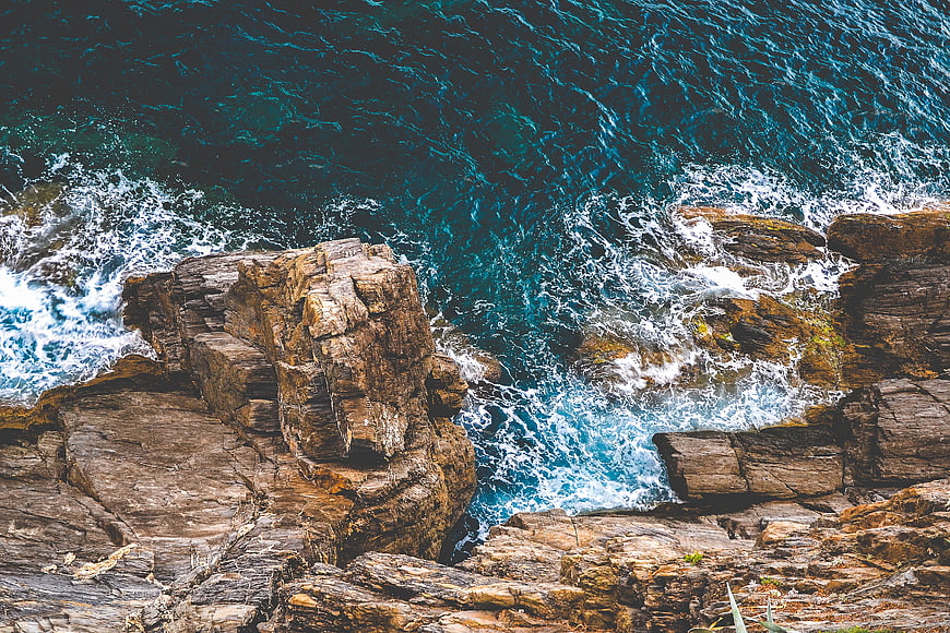 Aerial View of Turquoise Waves Crashing on Rocky Coastline