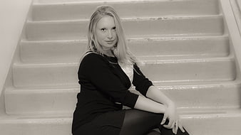 Black and white portrait of blonde woman sitting on stairs