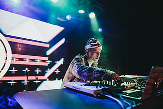 DJ performing on stage with Pioneer mixer and colorful lights
