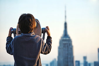 Woman Looking Through Binoculars at City Skyline