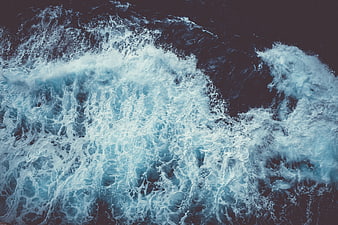 Aerial View of Turbulent Ocean Waves and Sea Foam