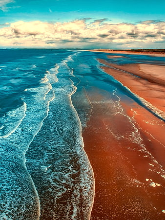 Aerial View of Ocean Waves Crashing on Sandy Beach