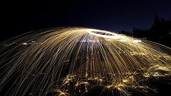 Steel wool sparks creating a glowing dome at night