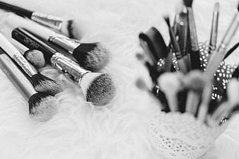 Black and white makeup brushes on white fur texture