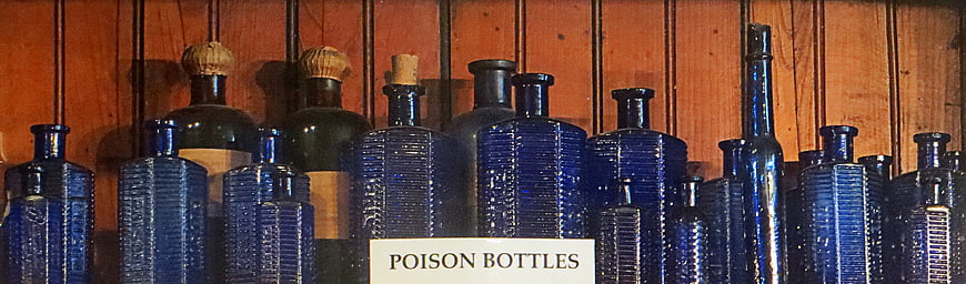 Vintage blue poison bottles on wooden shelf
