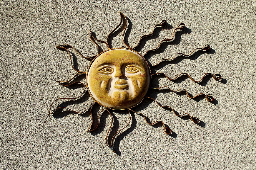 Rustic Sun Face Wall Sculpture on Textured Concrete