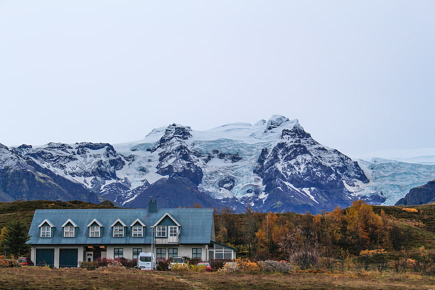 House with Glaciated Mountain Background in Autumn