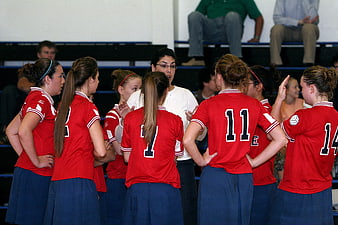 Female Volleyball Team Huddle with Coach in Gym
