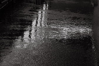 Black and white abstract wet asphalt texture with light reflection