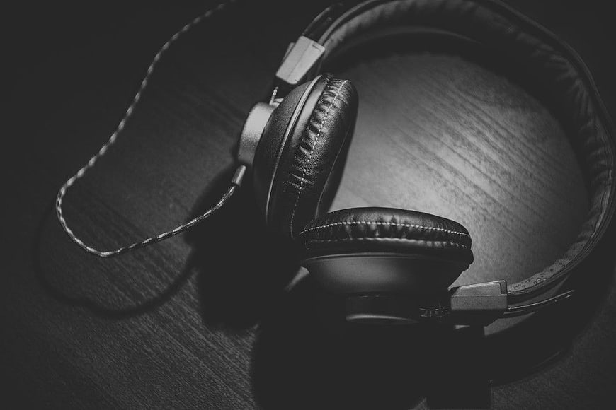 Black and white headphones on dark wooden surface