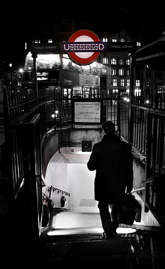 Man descending London Underground stairs at night