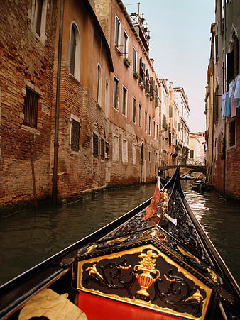 Gondola prow in narrow Venice canal with historic buildings