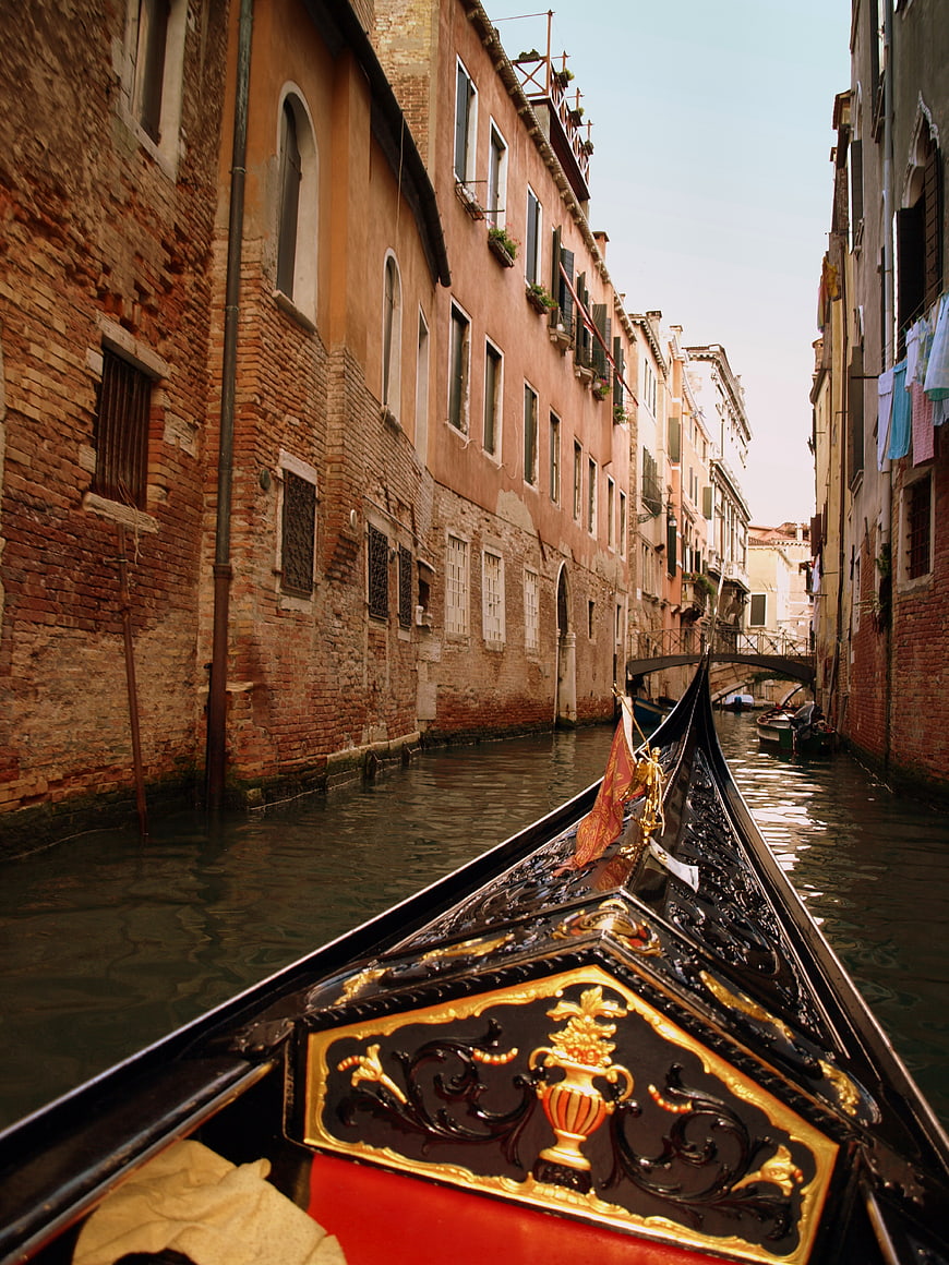 Gondola prow in narrow Venice canal with historic buildings