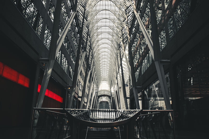 Modern glass atrium architecture with red accents