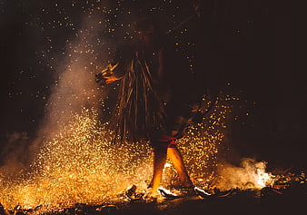 Fire dancer performing with sparks and smoke at night