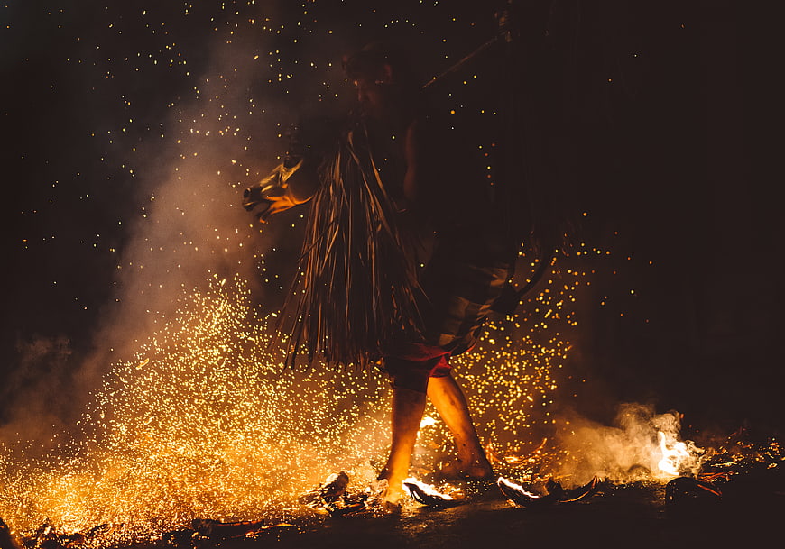 Fire dancer performing with sparks and smoke at night