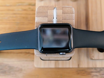 Black Smartwatch on Wooden Charging Stand