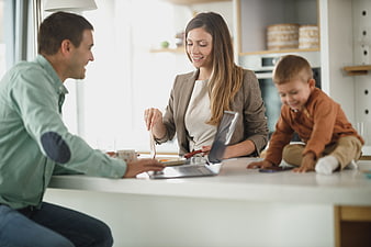 Happy family working together on laptop in modern kitchen