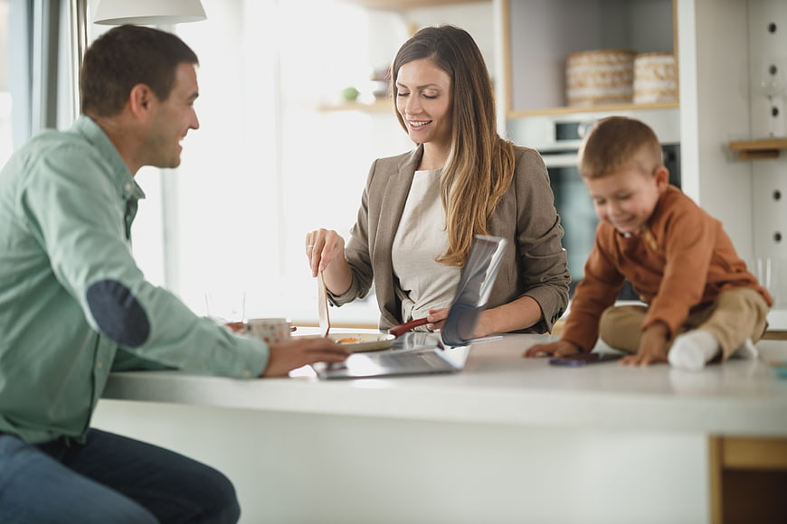 Happy family working together on laptop in modern kitchen