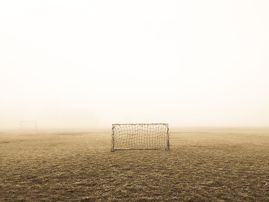 Lonely soccer goal on foggy field