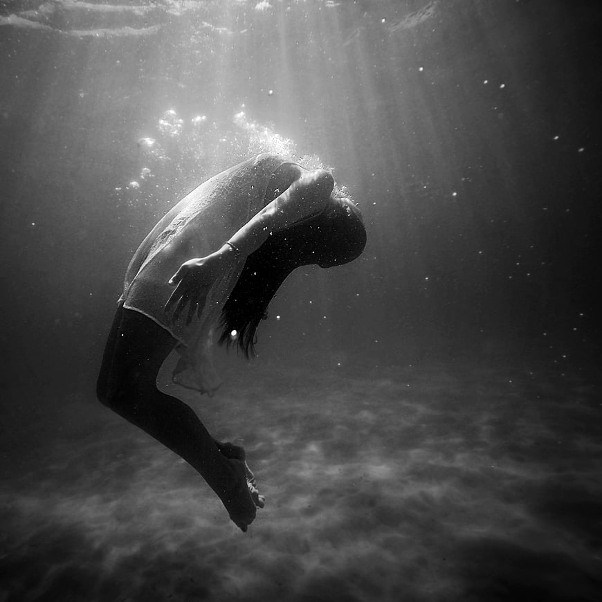 Woman Floating Underwater in Black and White