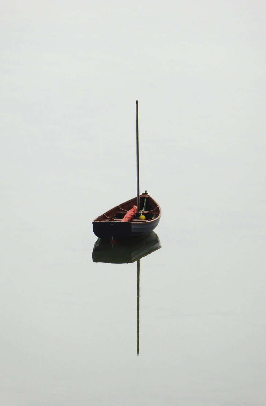 Minimalist Wooden Boat on Calm Misty Water