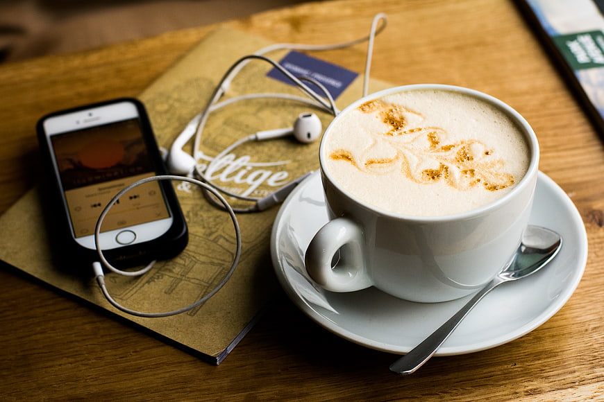 Latte with Smartphone and Earphones on Wooden Table