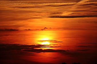 Vibrant orange sunset with dramatic clouds and glowing sun