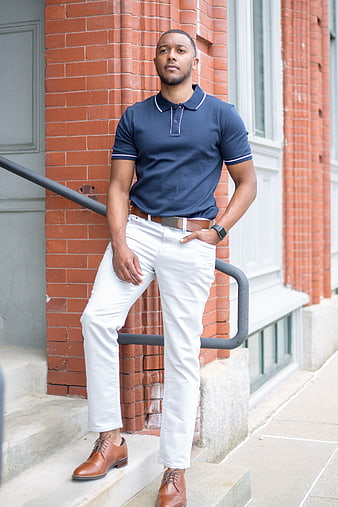 Confident Black Man in Navy Polo and White Pants on Urban Steps