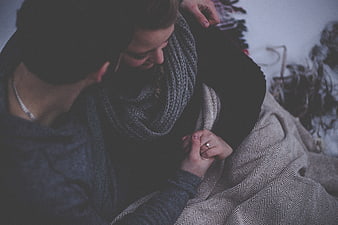 Couple Holding Hands With Ring Under Blanket