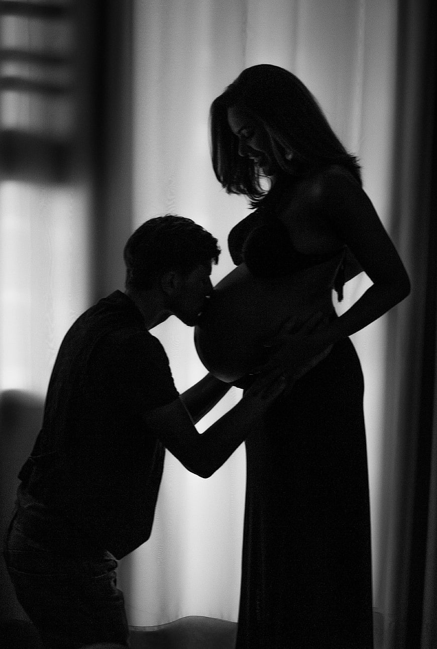 Silhouette of Pregnant Couple Kissing Belly
