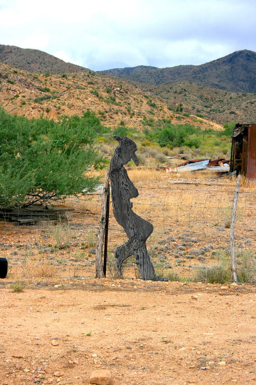 Wooden horse sculpture in desert landscape with mountains