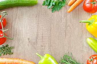 Fresh vegetables and herbs arranged on a wooden background