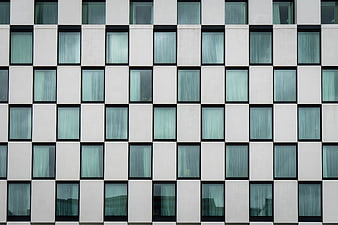 Modern white building facade with grid of blue windows