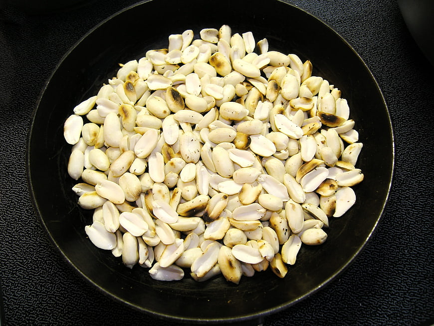 Toasted peanuts in a black frying pan