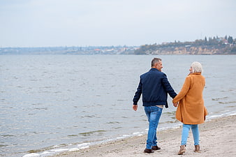 Senior couple walking hand in hand on a beach