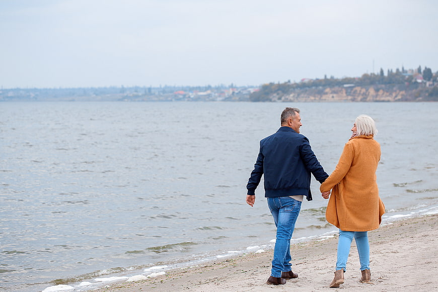 Senior couple walking hand in hand on a beach