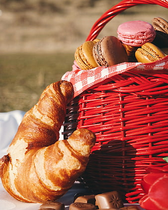 Red picnic basket with croissant and macarons