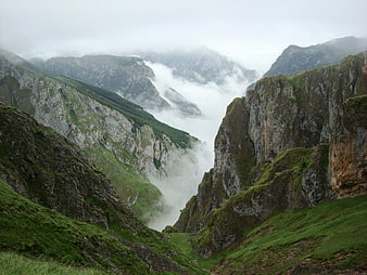 Misty Mountain Pass in Asturias with Dramatic Clouds and Green Valleys