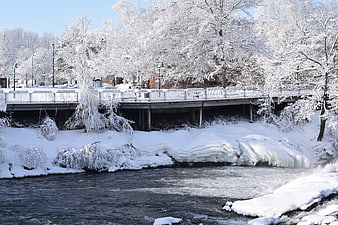Snow-covered bridge over a frozen river in winter