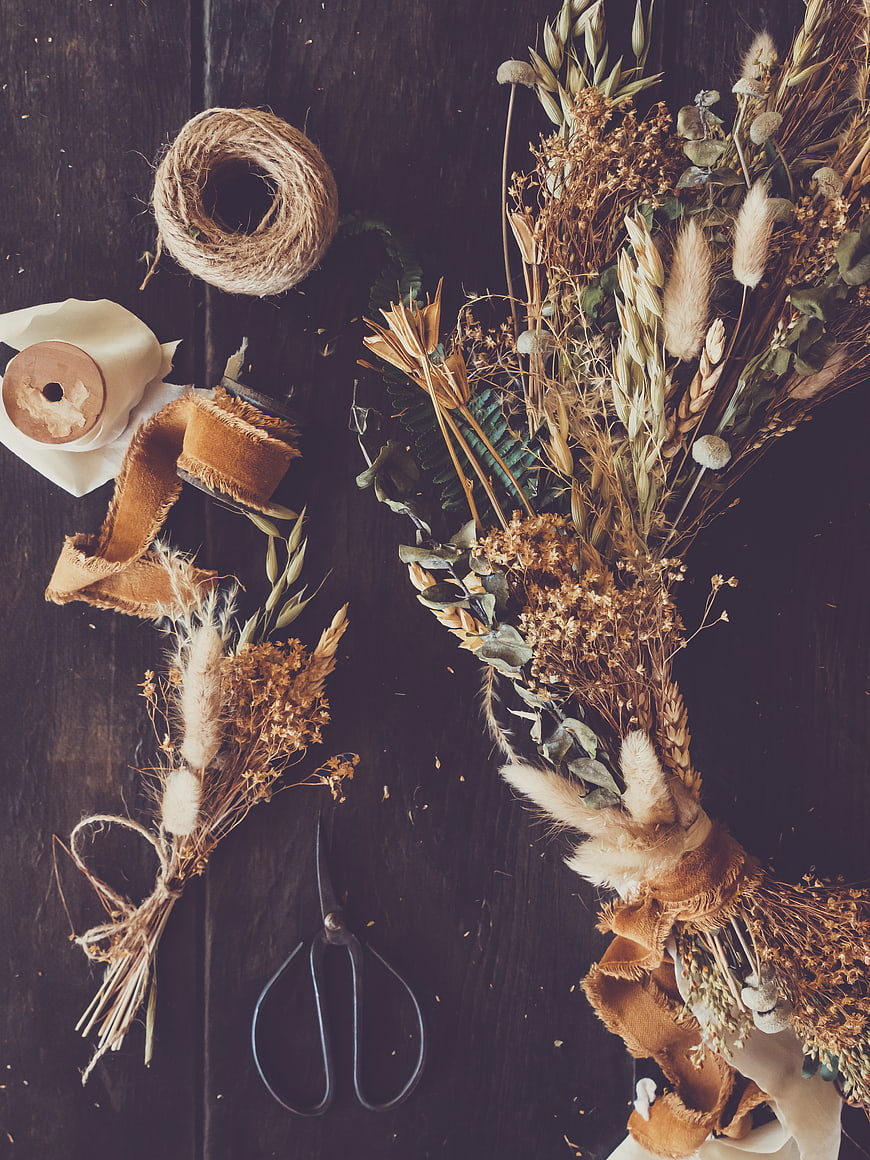 Rustic dried flower bouquet flat lay on dark wood
