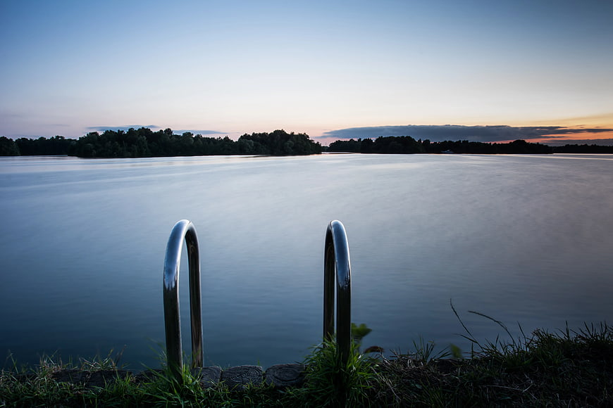 Serene Lake Sunset with Metal Ladder Rungs