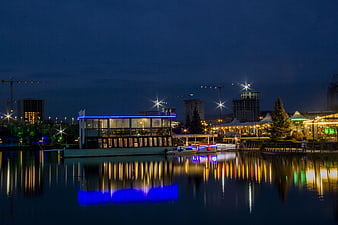 Night View of Illuminated Waterfront Restaurant and City Skyline