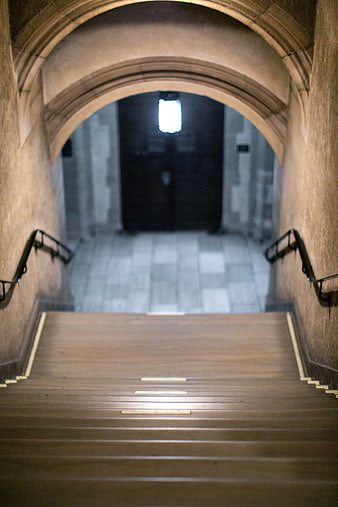 Stone Staircase Leading to Arched Hallway with Light