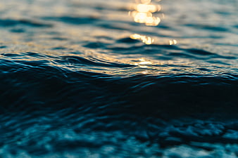 Close-up of ocean waves with golden sunlight reflection