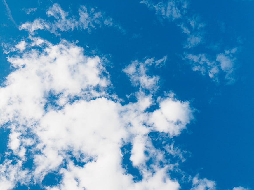 Fluffy White Clouds Against Vibrant Blue Sky Background