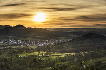 Panoramic sunset over rolling hills and village