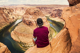 Man Sitting on Cliff Edge Overlooking Horseshoe Bend Canyon