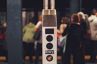 Subway turnstile entry sign with blurred commuters